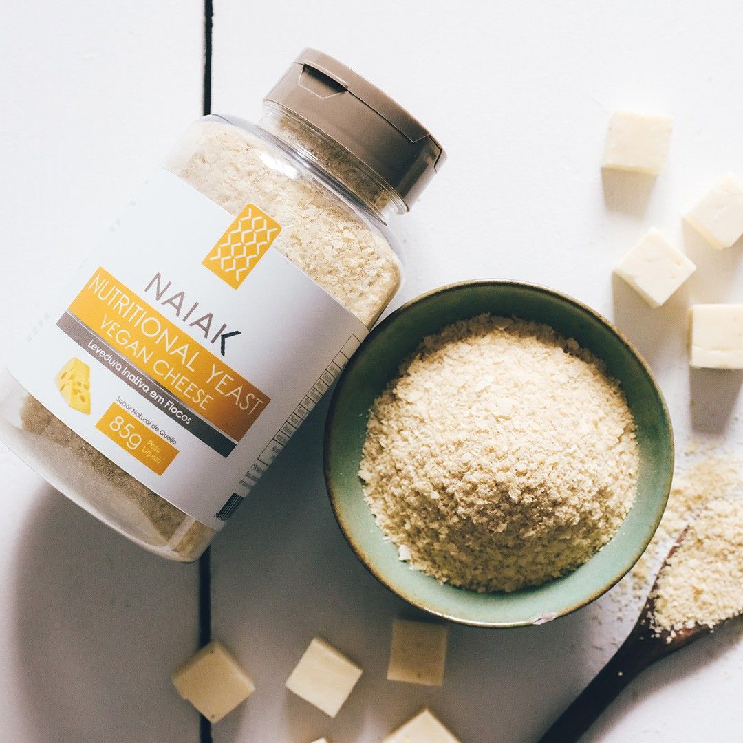 Pote de Nutritional Yeast Vegan Cheese ao lado de uma tigela com os flocos