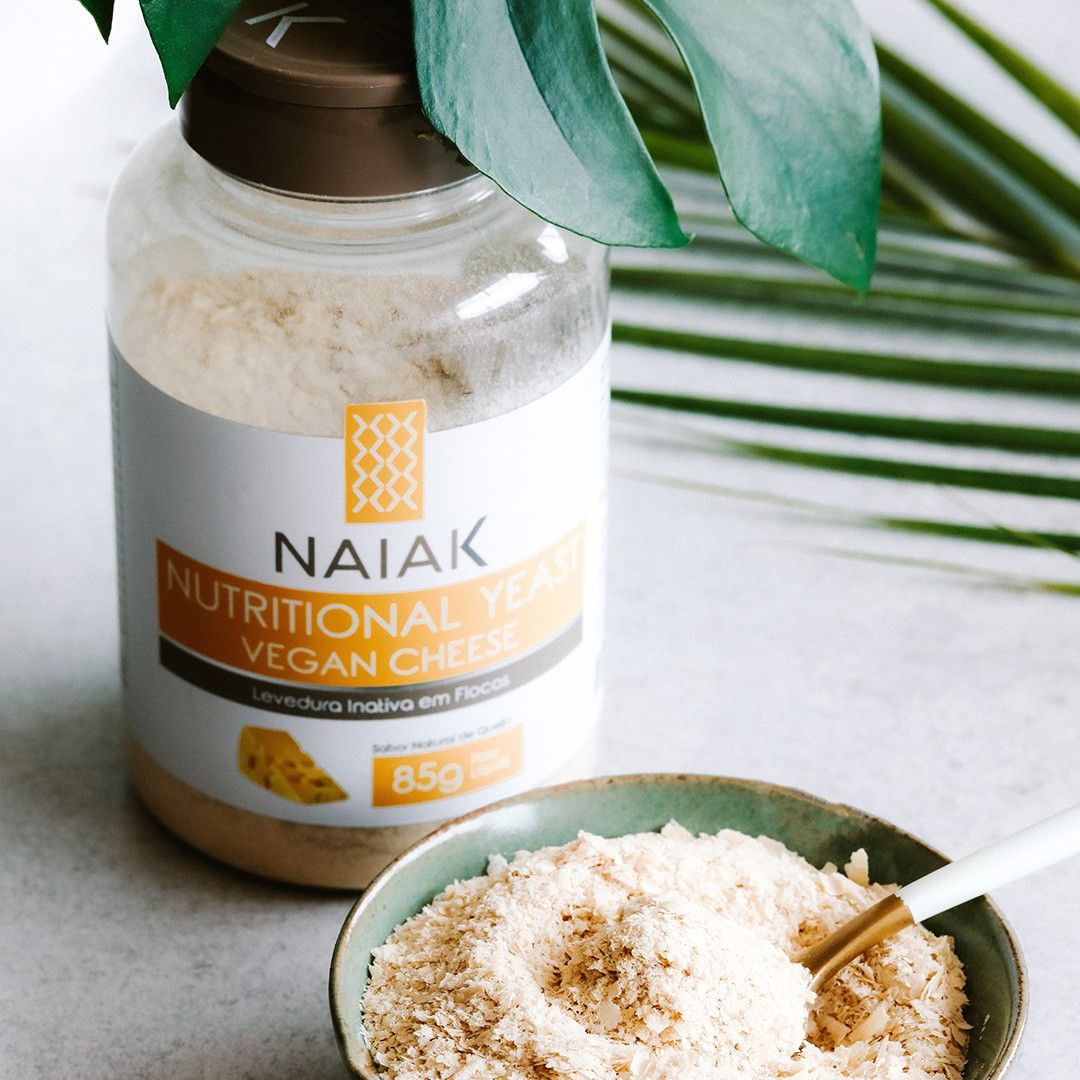 Nutritional Yeast Vegan Cheese Naiak: pote de 85 g com uma tigela dos flocos e folhas
